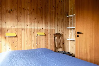 a bedroom with a wooden wall with a bed at Authentic Family Summer House At The Limfjord in Roslev