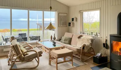 a living room with a couch and chairs and a fireplace at Summer House With Panoramic Views Of The Limfjord in Lihme