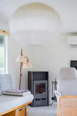 a living room with a fireplace and a chair at Experience 