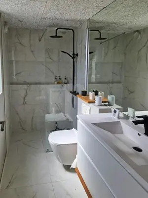 a white bathroom with a toilet and a sink at Panoramic Views Of Venø Bay At Handbjerg Marina