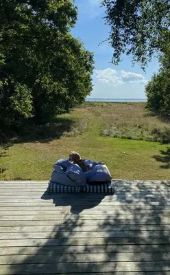 a person laying on an inflatablelatable bed on a patio at Architect-Designed House By Limfjord in Thyholm