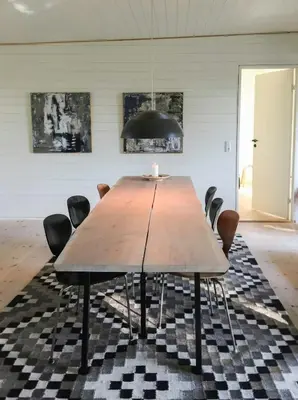 a dining room with a wooden table and chairs at Architect-Designed House By Limfjord in Thyholm