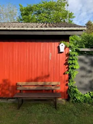 a bench sitting in front of a red building at Lifestyle Near Sea And Town in Nykøbing Mors