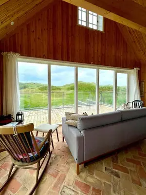 a living room with a couch and a large window at Luxury With Pool In Dunes Near Løkken in Løkken