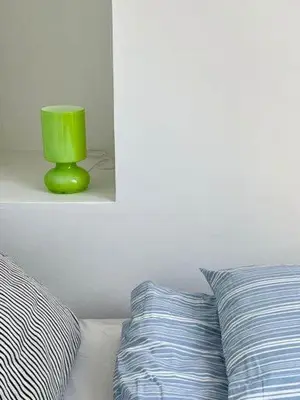 a green vase sitting on a shelf next to a bed at Luxury With Pool In Dunes Near Løkken in Løkken