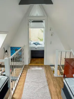 a attic room with a bed and a window at Summerhouse By The North Sea in Vestervig