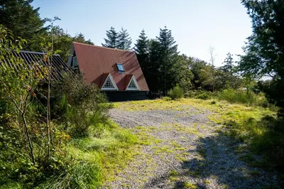 a house with a brown roof and a gravel yard at Summerhouse By The North Sea in Vestervig