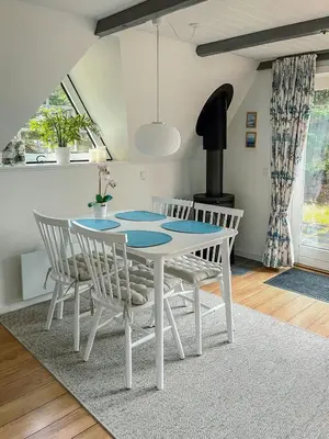 a dining room with a white table and chairs at Summerhouse By The North Sea in Vestervig