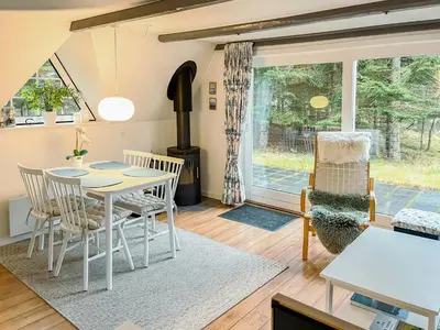 a living room with a table and chairs at Summerhouse By The North Sea in Vestervig