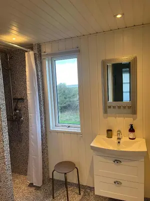 a bathroom with a sink and a window and a shower at Family Summer House Close To The North Sea in Vestervig