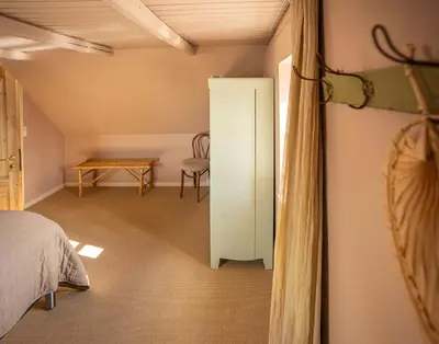 a bedroom with a bed and a table and a chair at Historic Fisherman's Gem With Twist In Klitmøller in Torsted