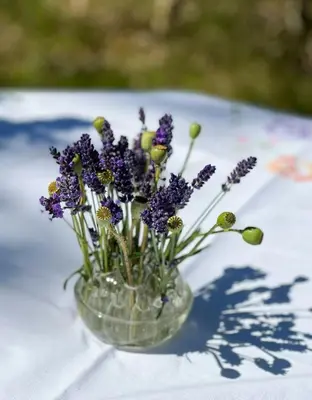 a glass vase filled with purple flowers on a table at Creative Family House Near Blokhus Beach in Blokhus