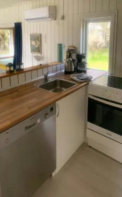 a kitchen with a sink and a stove at North Sea's Expanse Near Vorupør in Thisted