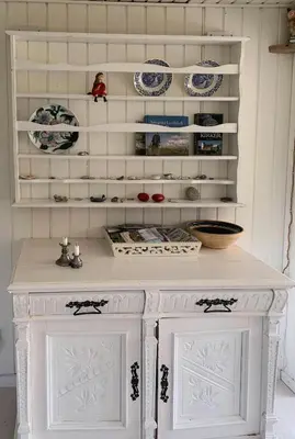 a white cabinet in a kitchen with plates on the shelves at North Sea's Expanse Near Vorupør in Thisted