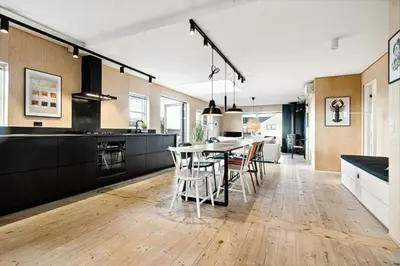 a kitchen and dining room with a table and chairs at Minimalist Coziness By The Wild North Sea in Harboør