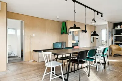 a kitchen and dining room with a table and chairs at Minimalist Coziness By The Wild North Sea in Harboør