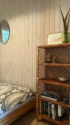 a bedroom with a book shelf next to a bed at Holiday Home In Tranum Forest in Brovst