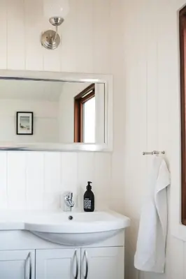 a white bathroom with a sink and a mirror at Architect-Designed House Close To The North Sea in Vestervig