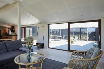 a living room with a couch and a glass table at Architect-Designed House Close To The North Sea in Vestervig