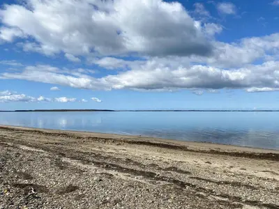 a beach with a cloudy sky and the water at Personlighed Arkitekttegnet Hus Ved Spøttrup in Spottrup