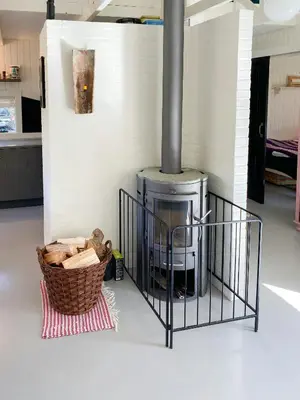 a fireplace in a room with a basket on the floor at Personlighed Arkitekttegnet Hus Ved Spøttrup in Spottrup
