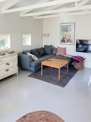 a living room with a blue couch and a coffee table at Personlighed Arkitekttegnet Hus Ved Spøttrup in Spottrup