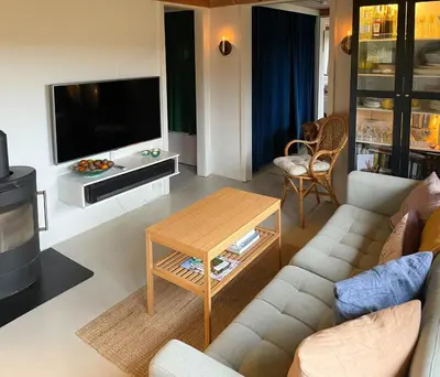 a living room with a couch and a tv at Cosy Holiday Home 260 Metres From Tranum Beach in Brovst