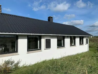 a white house with a black roof at Cosy Holiday Home 260 Metres From Tranum Beach in Brovst