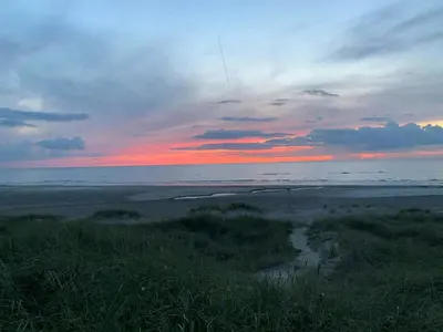 a sunset over a beach with the ocean at Cosy Holiday Home 260 Metres From Tranum Beach in Brovst