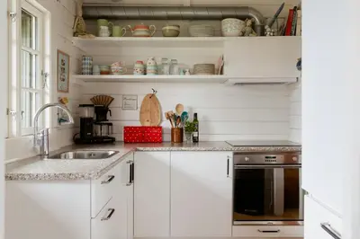 a kitchen with white cabinets and a sink at Grandma's House By Limfjord And Fur in Roslev