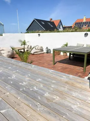 a deck with a picnic table and a bench at Historic House With Fjord View On Venø in Vemb
