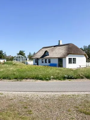 a white house on the side of a road at Historic House With Fjord View On Venø in Vemb