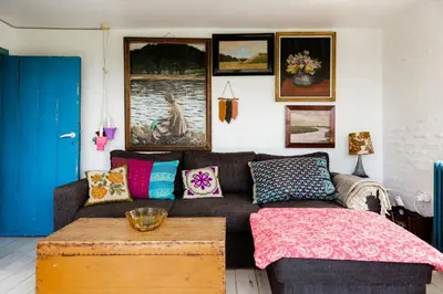 a living room with a couch and a table at Magical Farm House Right Next To The Sea in Lemvig