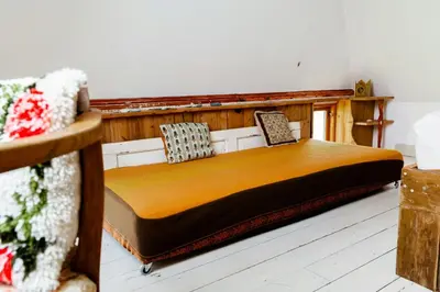 a bedroom with a wooden bed in a room at Magical Farm House Right Next To The Sea in Lemvig