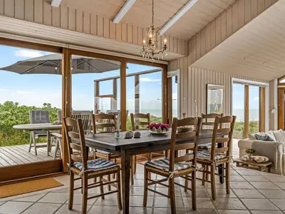 a dining room with a table and chairs at Holiday Home Bjerund - 300m from the sea by Interhome in Løkken
