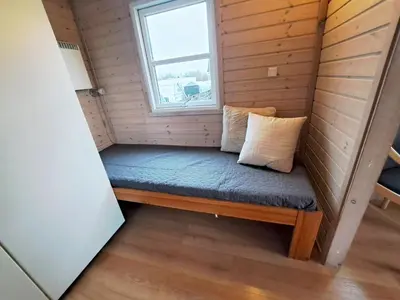 a bench in a tiny house with a window at Toftum Bjerge Camping & Cottages in Humlum