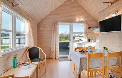 a kitchen and dining room with a table and chairs at Toftum Bjerge Camping & Cottages in Humlum