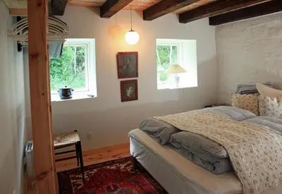 a bedroom with a bed and two windows at Alt det bedste mellem hav og fjord - en hel bolig in Brovst