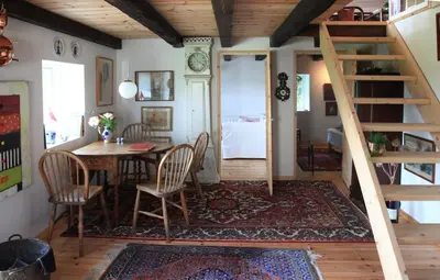 a room with a table and chairs and a staircase at Alt det bedste mellem hav og fjord - en hel bolig in Brovst