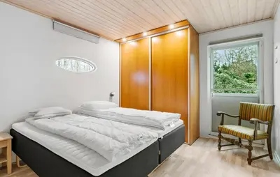 a bedroom with a large bed and a chair at Amazing Home In Højslev With Sauna in Højslev