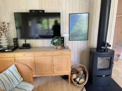 a living room with a tv and a wood stove at Sommerhus i Rødhus Blokhus in Pandrup