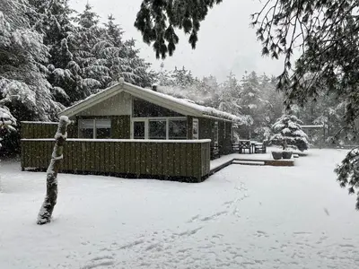 a house covered in snow in a yard at Sommerhus i Rødhus Blokhus in Pandrup