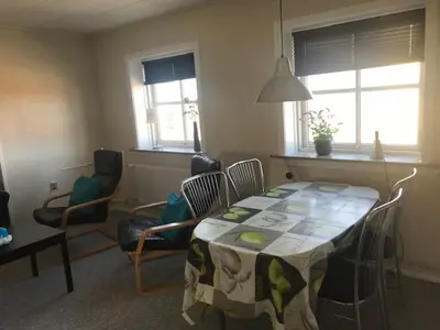 a living room with a table and chairs and a dining room at Svanegade 1 , 2 sal in Thyborøn