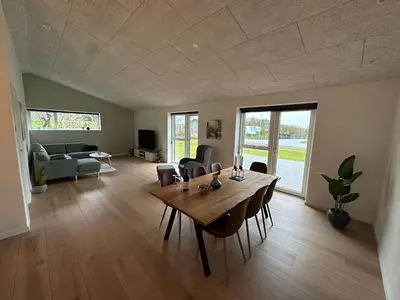 a living room with a wooden table and chairs at Moderne nybygget in Holstebro