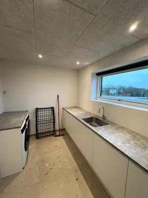 an empty kitchen with a sink and a window at Moderne nybygget in Holstebro