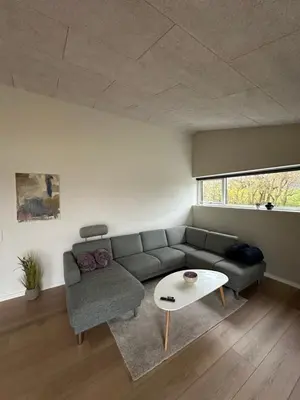 a living room with a couch and a table at Moderne nybygget in Holstebro