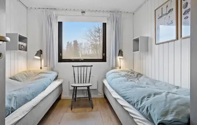 a bedroom with two beds and a chair and a window at Amazing Home In Spøttrup With Wifi in Lihme