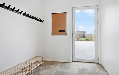 a white room with a door and a bench at Nice Home In Højslev With Sauna in Højslev