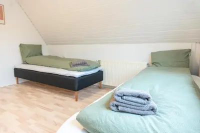 a room with two beds with towels on them at Villa Holstebro in Holstebro