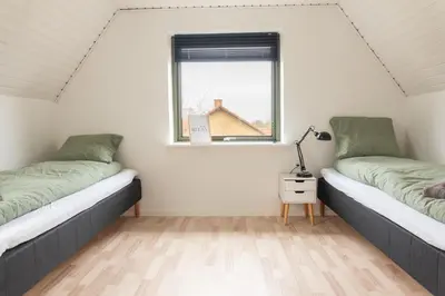two beds in a room with a window at Villa Holstebro in Holstebro